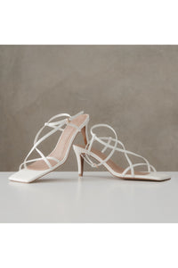 vegan leather heels, white, the stella multistrap strappy heel in white vegan leather. stood against a stone backdrop