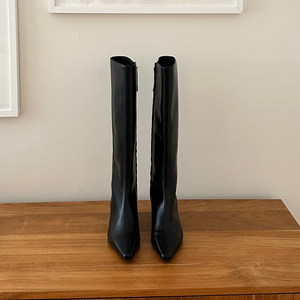 Knee high boot, luxury vegan leather knee high boot, on a wooden surface white backdrop