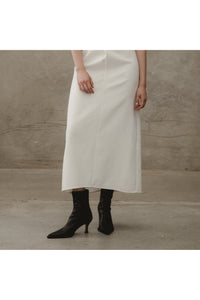 black vegan leather boots worn by a model with a white dress. Edie collective the original boot