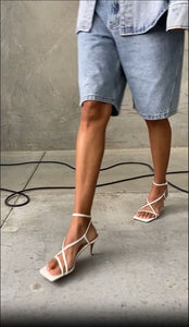 a model walks in the Stella Multi Strap white vegan leather heel - edie collective